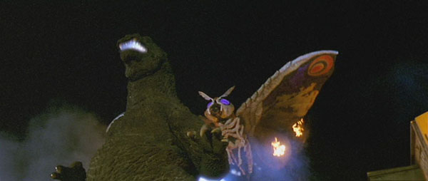File:Mothra approaching Godzilla's back.jpg